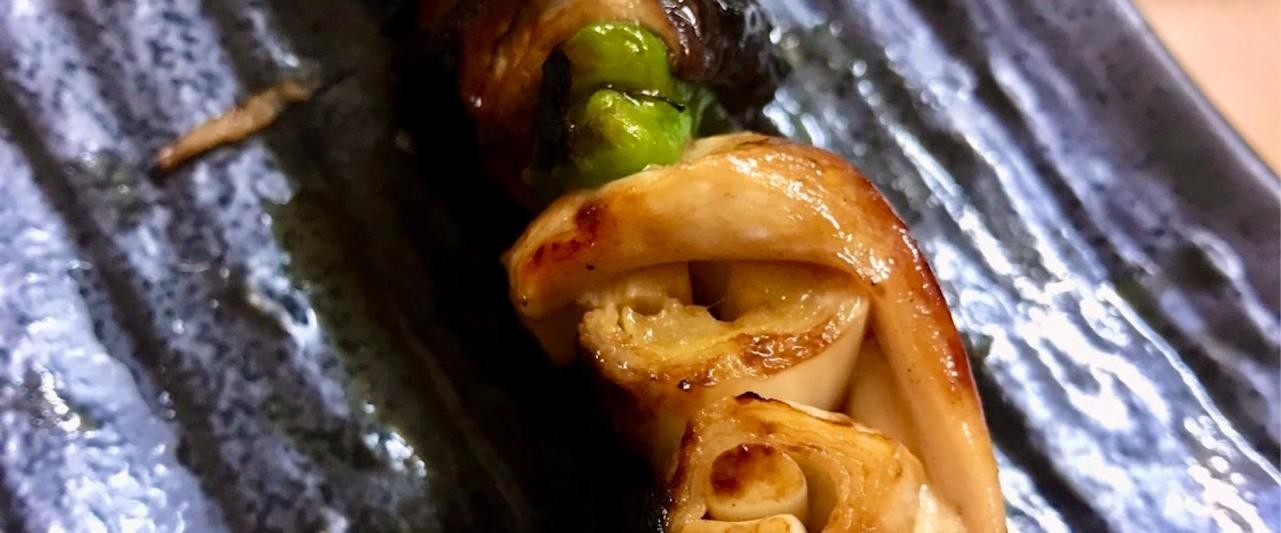緑の野菜と一緒に焼いた串のアップ