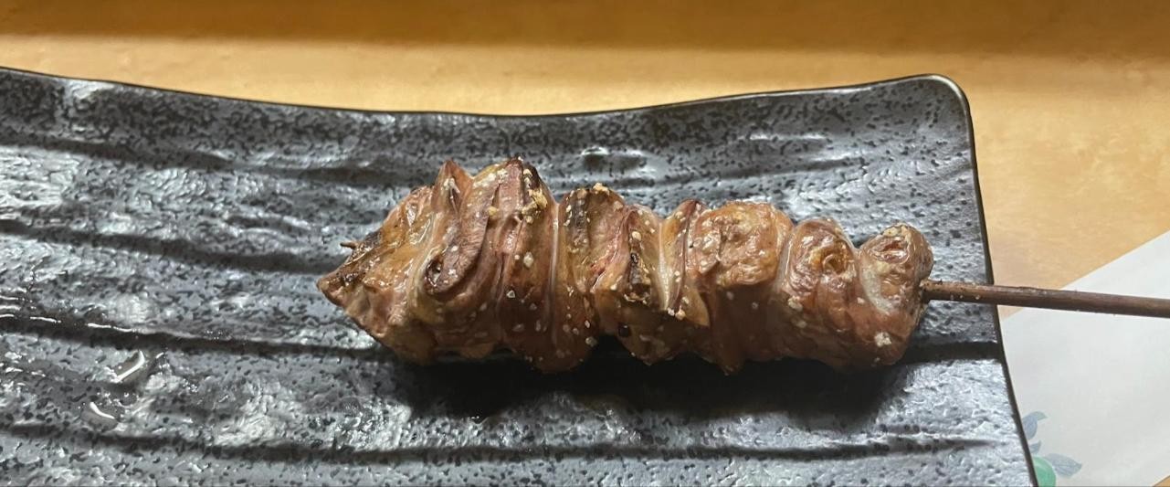黒い皿にのった焼き鳥の串